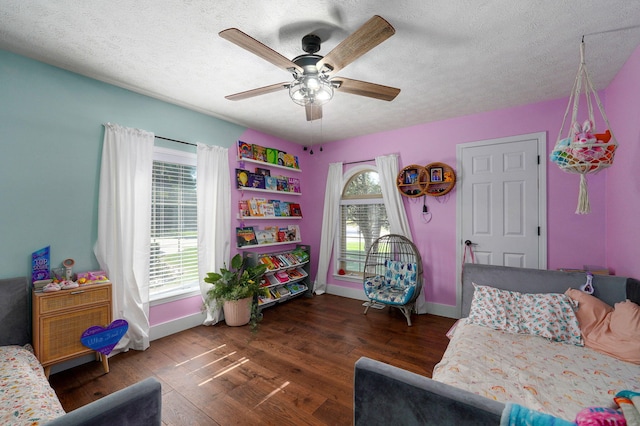 bedroom featuring ceiling fan, dark hardwood / wood-style floors, and a textured ceiling