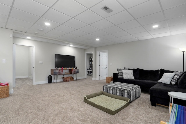 living room with carpet flooring and a paneled ceiling