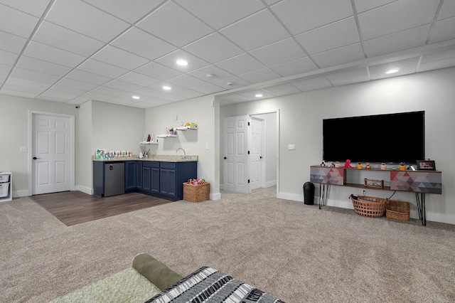 carpeted living room with a drop ceiling