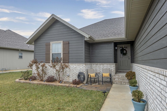 entrance to property with a patio area and a lawn