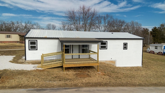 view of front facade featuring a wooden deck and a front lawn