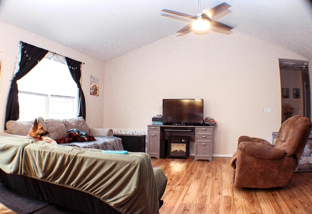 living room with ceiling fan, lofted ceiling, and light hardwood / wood-style floors