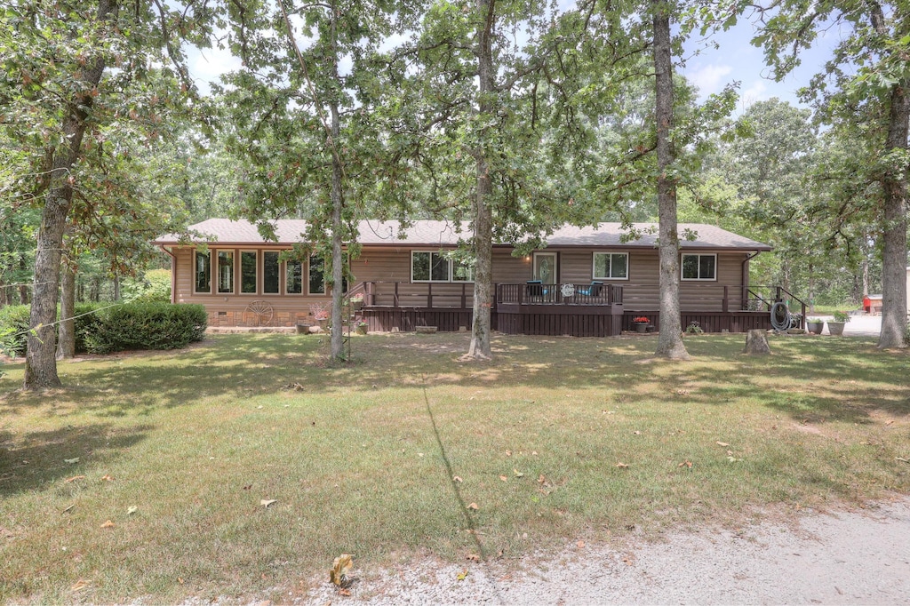 back of house featuring a lawn and a deck