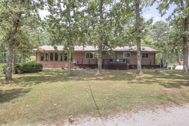 back of house featuring a lawn and a deck