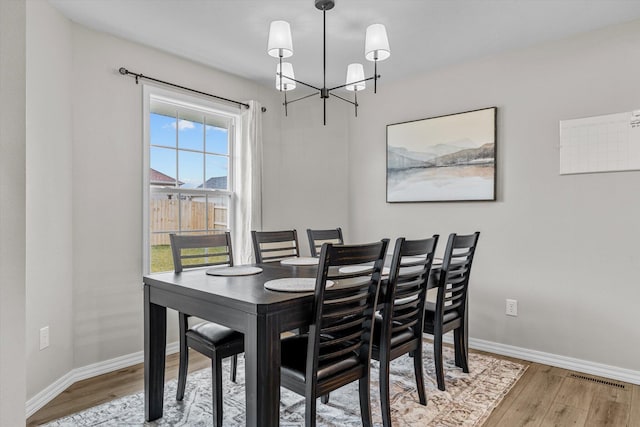 dining area featuring an inviting chandelier and hardwood / wood-style floors