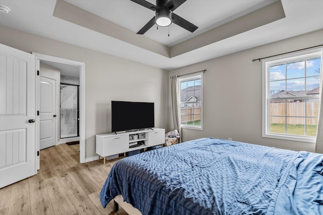 bedroom featuring light hardwood / wood-style flooring and a tray ceiling