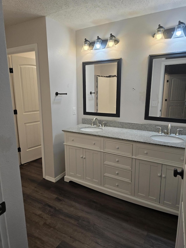 bathroom featuring vanity, hardwood / wood-style flooring, and a textured ceiling