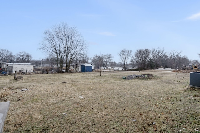 view of yard featuring a shed and central AC