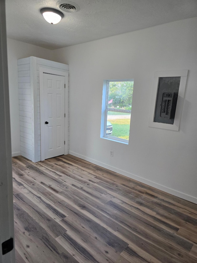 unfurnished room with hardwood / wood-style floors and a textured ceiling