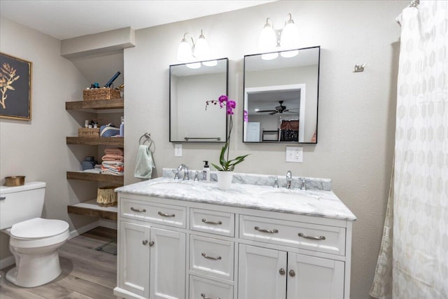 bathroom featuring ceiling fan, vanity, toilet, and wood-type flooring