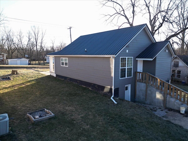 view of home's exterior with cooling unit and a lawn