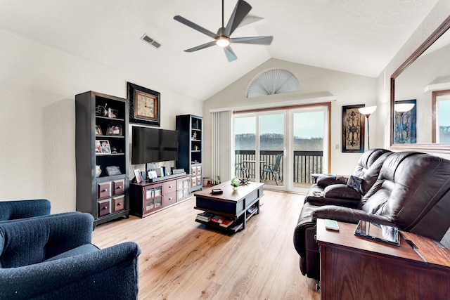 living room with ceiling fan, lofted ceiling, and light wood-type flooring