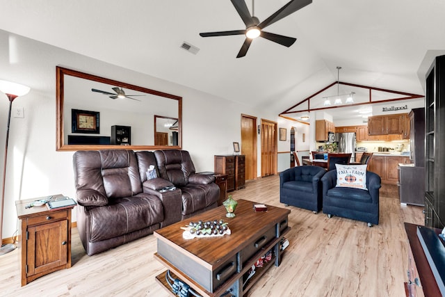 living room with ceiling fan, lofted ceiling, and light hardwood / wood-style floors