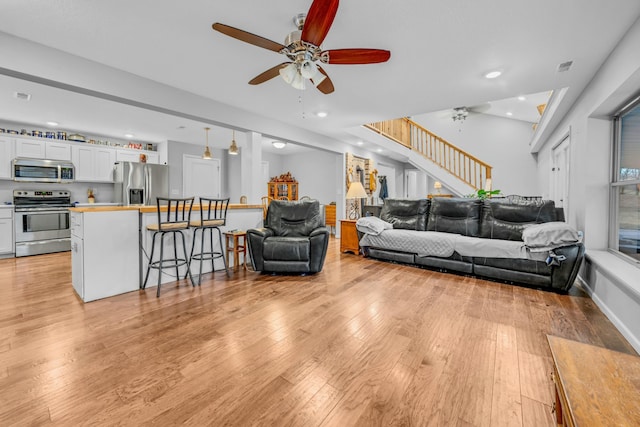 living room featuring ceiling fan and light wood-type flooring