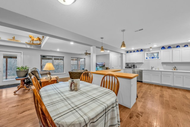 dining area featuring sink, light hardwood / wood-style flooring, and plenty of natural light