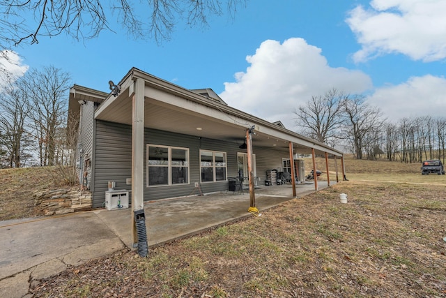 back of house featuring a patio area and a lawn