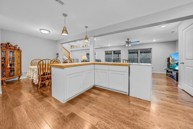 kitchen with white cabinetry, ceiling fan, decorative light fixtures, and light wood-type flooring