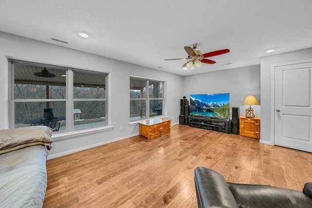 living room with ceiling fan and light hardwood / wood-style flooring