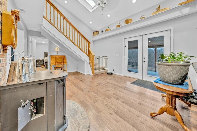 entrance foyer with french doors, light wood-type flooring, and a skylight