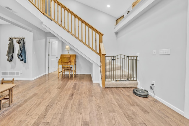 staircase featuring hardwood / wood-style floors and a high ceiling