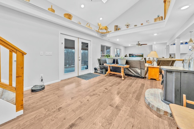 living room featuring high vaulted ceiling, light hardwood / wood-style floors, french doors, and ceiling fan