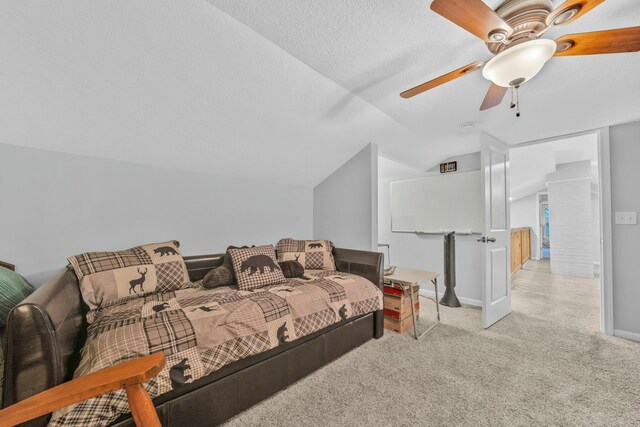 carpeted bedroom with ceiling fan, vaulted ceiling, and a textured ceiling