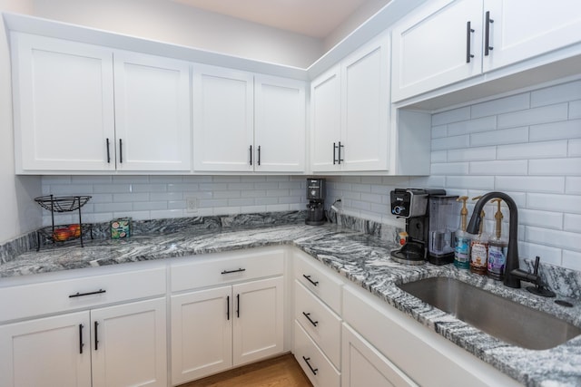 kitchen with white cabinetry, sink, and tasteful backsplash