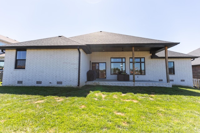 rear view of property featuring a yard and a patio area