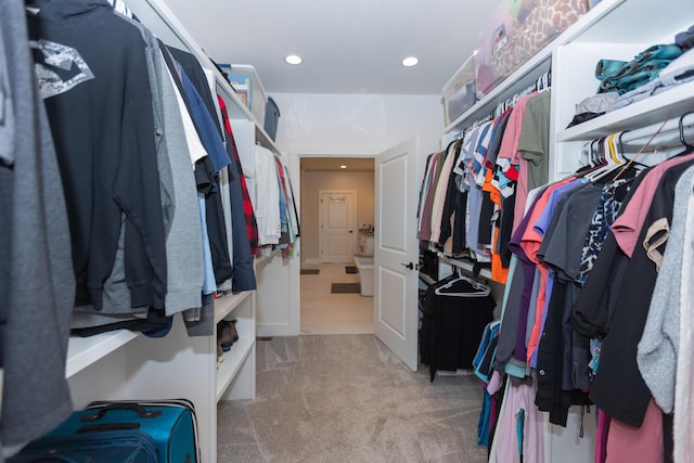 spacious closet featuring light colored carpet