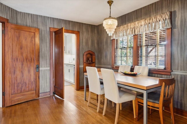 dining room with hardwood / wood-style floors and an inviting chandelier