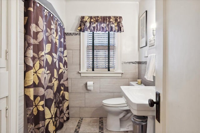 bathroom with tile walls, tile patterned flooring, and toilet