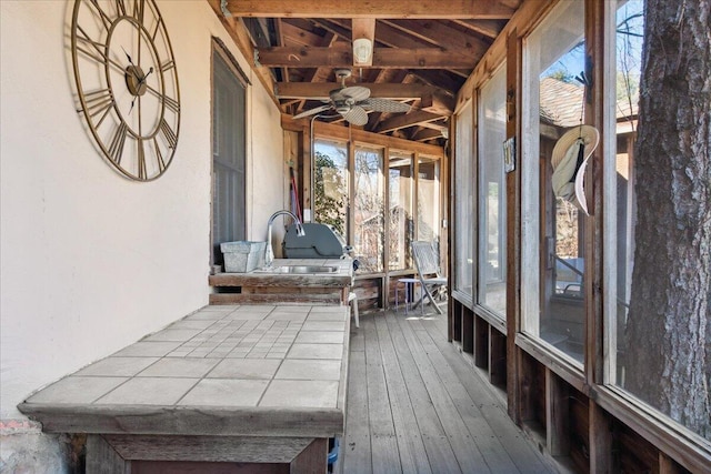 unfurnished sunroom featuring sink, a wealth of natural light, and ceiling fan