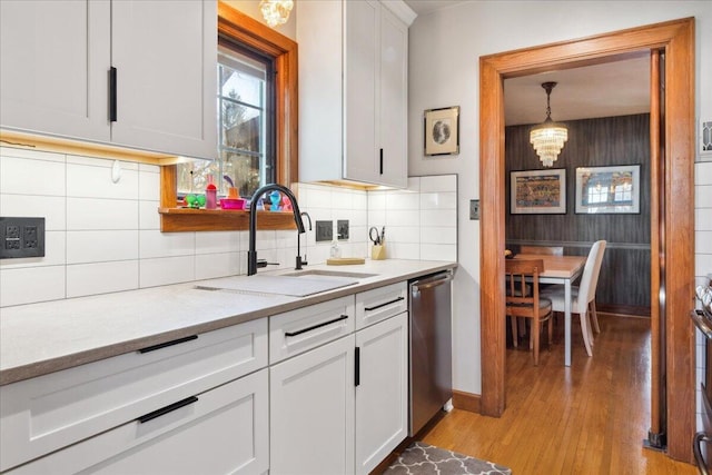 kitchen featuring white cabinetry, sink, dishwasher, and light wood-type flooring