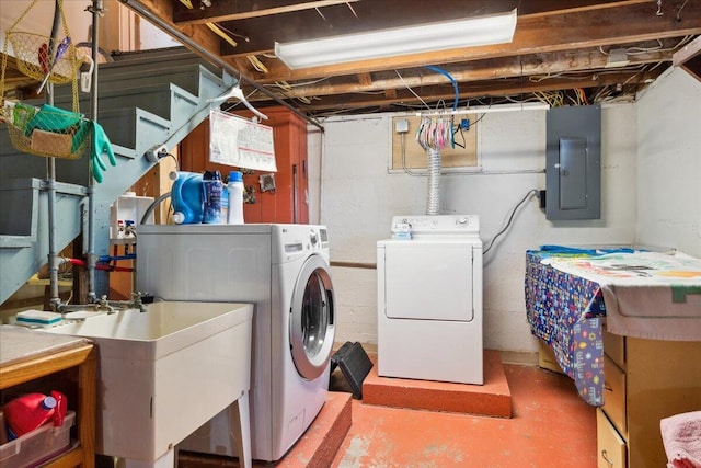 washroom featuring sink, electric panel, and washer and clothes dryer