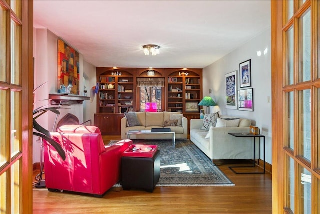 living room with hardwood / wood-style floors and built in shelves