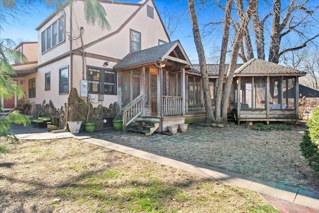 view of front of house with a sunroom and a front yard