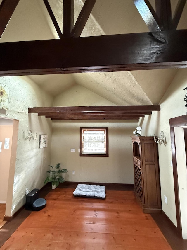 bonus room featuring hardwood / wood-style flooring and lofted ceiling with beams