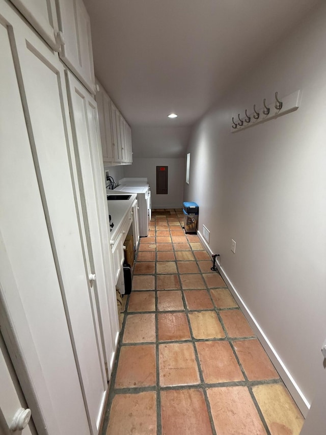 washroom with washing machine and dryer, cabinets, and electric panel