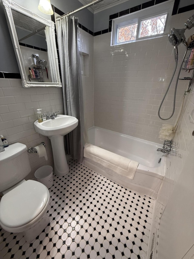 full bathroom with toilet, shower / bathtub combination with curtain, sink, and tile walls