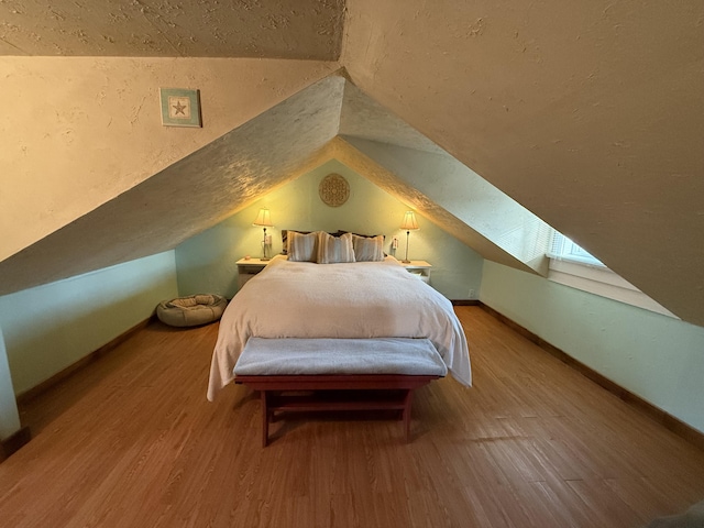 bedroom featuring lofted ceiling and hardwood / wood-style floors