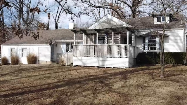 back of house featuring a lawn and covered porch