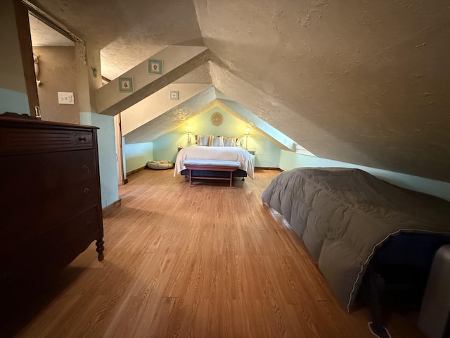 bedroom with light hardwood / wood-style flooring and vaulted ceiling