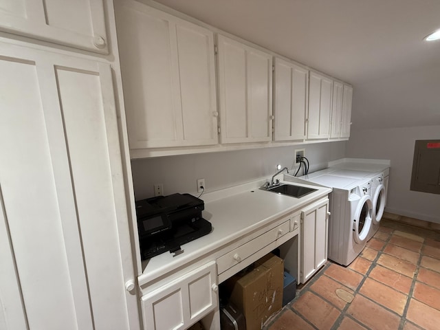 washroom featuring sink, washing machine and dryer, and cabinets