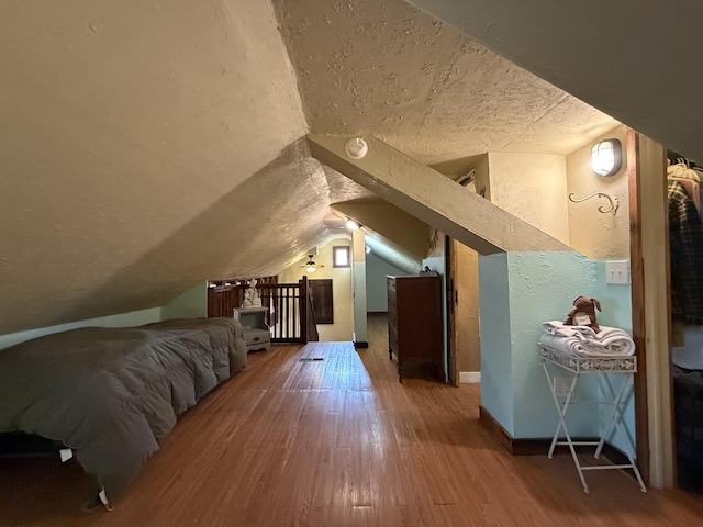 additional living space with wood-type flooring and vaulted ceiling