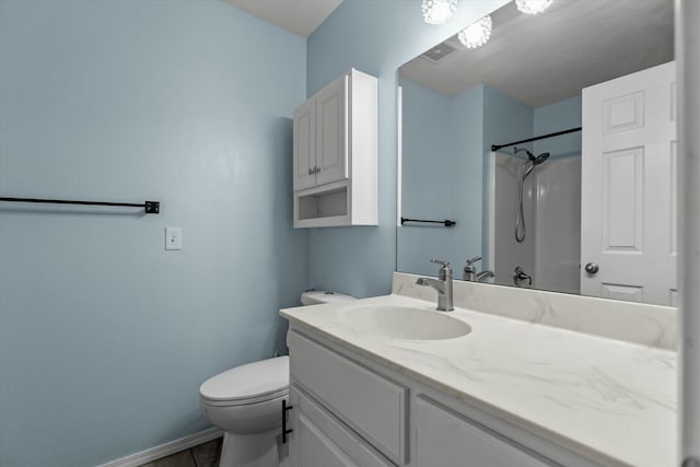 bathroom featuring vanity, tile patterned flooring, toilet, and a shower