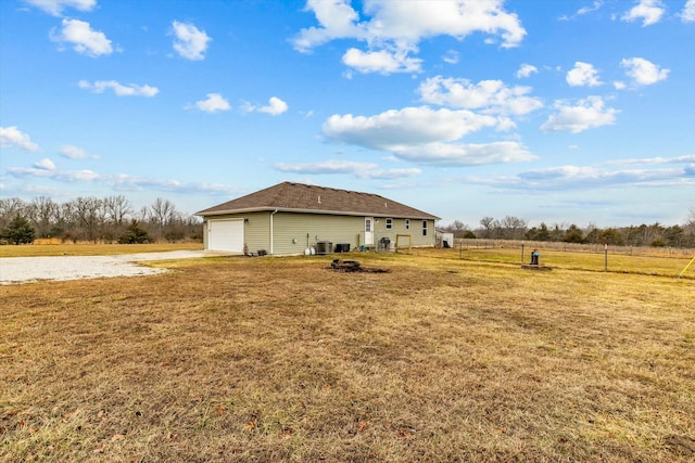 exterior space featuring a garage, an outbuilding, a rural view, and cooling unit