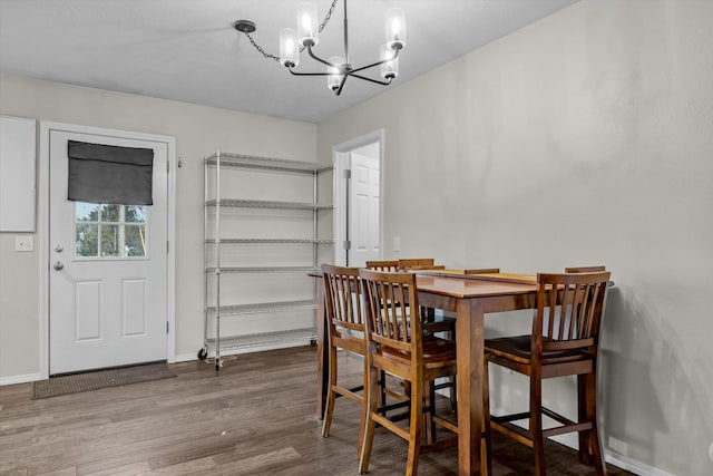 dining room with dark hardwood / wood-style floors and a notable chandelier