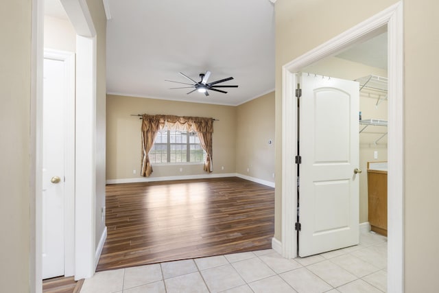 empty room featuring crown molding, light hardwood / wood-style flooring, and ceiling fan