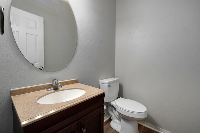 bathroom with vanity, toilet, and wood-type flooring