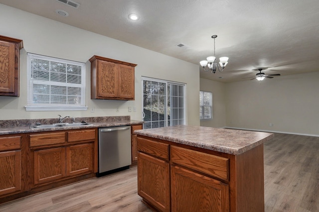 kitchen with sink, light hardwood / wood-style flooring, a center island, decorative light fixtures, and stainless steel dishwasher